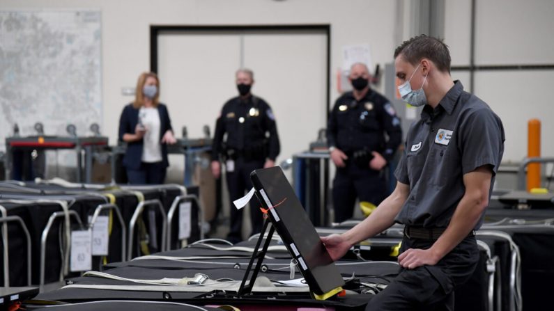 Un employé du comté de Clark vérifie une machine de vote parmi d'autres qui sont emballées au département électoral du comté de Clark à Las Vegas, Nevada, le 6 novembre. (Ethan Miller/Getty Images)