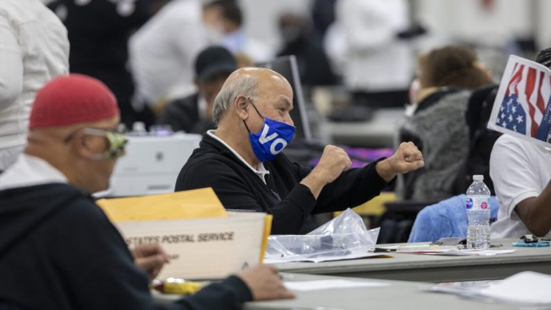 Un employé du département des élections de Détroit se réjouit en entendant le nombre presque final de 167 000 bulletins de vote par correspondance dépouillés, qui a été annoncé par haut-parleur au bureau central de dépouillement du centre TCF de Détroit, dans le Michigan, le 4 novembre. (Elaine Cromie/Getty Images)