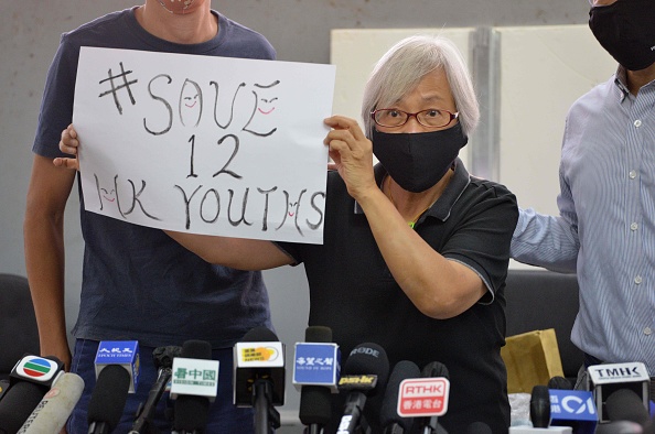 -Alexandra Wong, une manifestante pro- démocratie de 64 ans, tient une pancarte pour souligner le sort de 12 jeunes de Hong Kong emprisonnés sur le continent, à Hong Kong le 17 octobre 2020. Photo par Peter Parks / AFP via Getty Images.