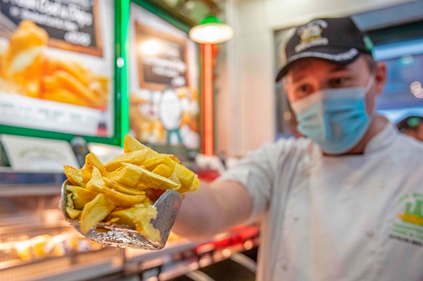 -Conor Fitzpatrick tient une portion de chips fraîchement frites dans le magasin Leo Burdock Fish and Chips du centre de Dublin le 2 décembre 2020. Photo de Paul Faith / AFP via Getty Images.