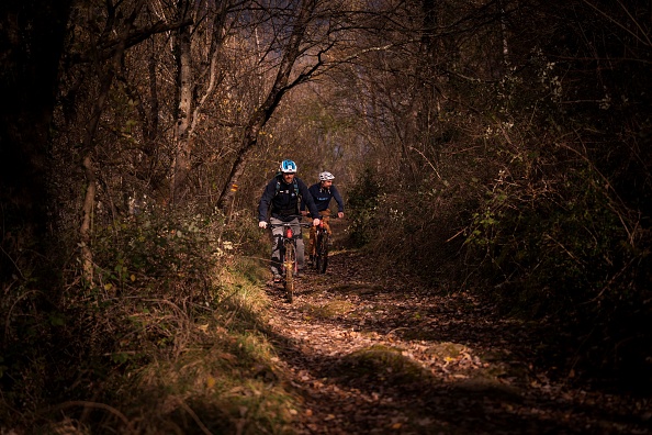 David Labarre, 32 ans et ancien joueur international français de football à cinq, monte son vélo aux côtés de son moniteur de VTT Laurent, dans le cadre de sa formation pour ses futures expéditions, le 8 décembre 2020 à Aspet, dans le sud de la France. Photo par Lionel Bonaventure / AFP via Getty Images.