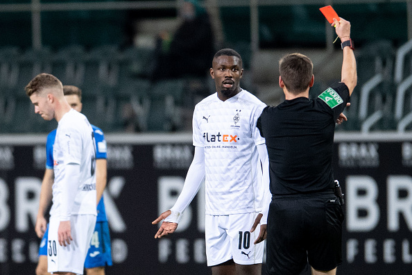 L'arbitre Frank Willenborg montre le carton rouge à Marcus Thuram, lors du match de football de première division allemande Borussia Moenchengladbach contre TSG 1899 Hoffenheim à Moenchengladbach, le 19 décembre 2020. (Photo : MARIUS BECKER/POOL/AFP via Getty Images)