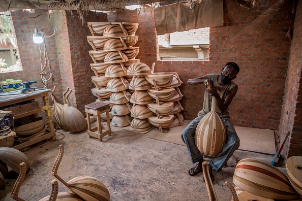 -Un homme travaille dans un atelier appartenant à Khaled Azzouz, un vétéran fabricant de oud à la périphérie de la capitale égyptienne Le Caire le 26 octobre 2020. Photo by Khaled Desouki / AFP via Getty Images.