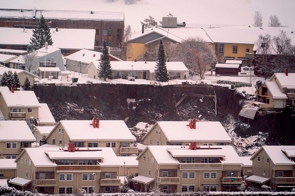 -Des maisons détruites sont vues dans un cratère laissé par un glissement de terrain dans la ville d'Ask, à environ 40 km au nord-est de la capitale Oslo, le 31 décembre 2020. Photo par Fredrik Hagen / NTB / AFP via Getty Images.