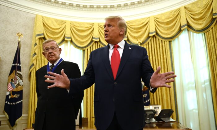 Le président américain Donald Trump s'exprime, après avoir remis la Médaille présidentielle de la liberté à l'entraîneur de football à la retraite Lou Holtz (à gauche), dans le Bureau ovale de la Maison Blanche, à Washington, le 3 décembre 2020. (Brendan Smialowski/AFP via Getty Images)
