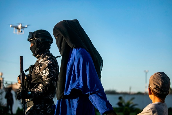 Les Forces démocratiques syriennes (SDF) escortent une femme et un enfant.    (Photo : DELIL SOULEIMAN/AFP via Getty Images)