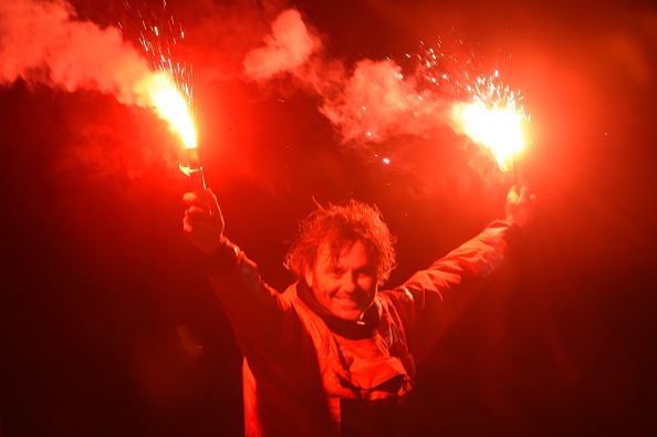 -Le Français Yannick Bestaven célèbre avec des fusées éclairantes après avoir franchi la ligne d'arrivée de l'édition 2020/2021 du Vendée Globe. Photo par Jean-François Monier / AFP via Getty Images.