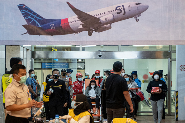 Des proches de passagers du vol SJ 182 de Sriwijaya Air quittent le centre de crise de l'aéroport Soekarno Hatta, le 9 janvier 2021 à Jakarta, en Indonésie. Le vol SJY182 de Sriwijaya Air transportant 62 personnes à bord d'un vol reliant la capitale indonésienne à Pontianak, en Indonésie, a perdu le contact avec des contrôleurs aériens peu de temps après le décollage et on pense qu'il s'est écrasé dans les eaux au large de Jakarta. (Photo : Oscar Siagian/Getty Images)