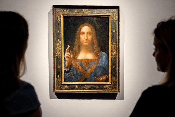 -Les employés de Christie's posent devant un tableau intitulé Salvator Mundi dans le centre de Londres le 22 octobre 2017. Photo Tolga Akmen/AFP via Getty Images.