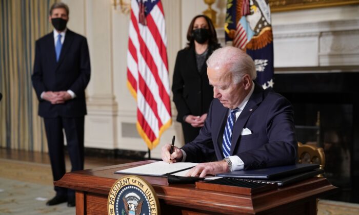 Le vice-président américain Kamala Harris (2e à gauche) et l'envoyé spécial du président pour le climat John Kerry (à gauche) regardent le président américain Joe Biden signer des décrets après son discours sur la lutte contre le changement climatique, la création d'emplois et la restauration de l'intégrité scientifique dans la salle à manger de la Maison-Blanche le 27 janvier 2021. (MANDEL NGAN/AFP via Getty Images)