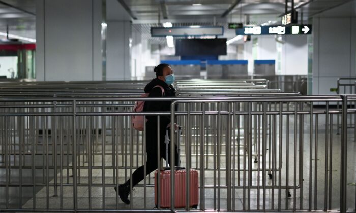 Une femme portant un masque marche dans une station de métro à Pékin le 28 mars 2020. (Wang Zhao/AFP via Getty Images)