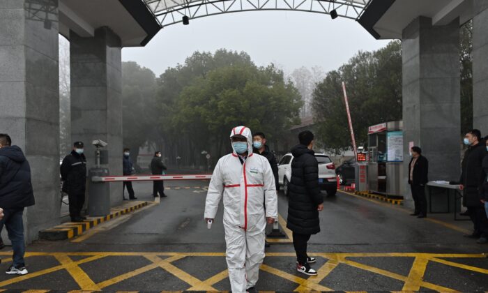 Un garde portant un équipement de protection se trouve à l'entrée du centre de contrôle et de prévention des maladies de la province du Hubei alors que les membres de l'équipe de l'Organisation mondiale de la santé chargée d'enquêter sur les origines du Covid-19 se rendent sur place à Wuhan, dans la province centrale du Hubei, en Chine, le 1er février 2021. (Photo par HECTOR RETAMAL / AFP) (Photo par HECTOR RETAMAL/AFP via Getty Images)