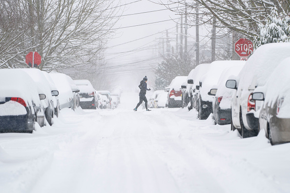 -Un jogger fait son parcours à travers une rue enneigée le 13 février 2021 à Seattle, Washington. Photo par David Ryder / Getty Images.