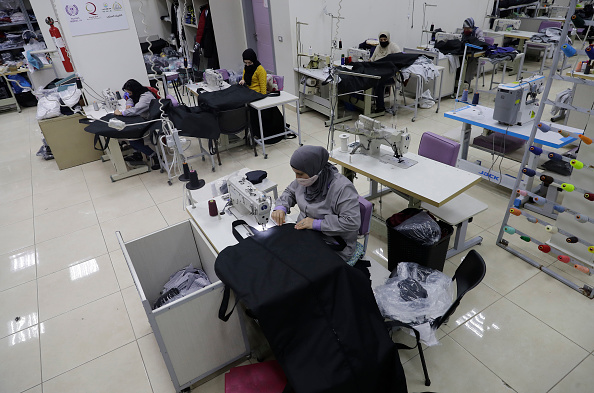 -Des couturières cousent des sacs mortuaires pour les victimes du virus du PCC dans l'usine de couture, au sud de Beyrouth, le 16 février 2021. Photo de Joseph Eid / AFP via Getty Images.