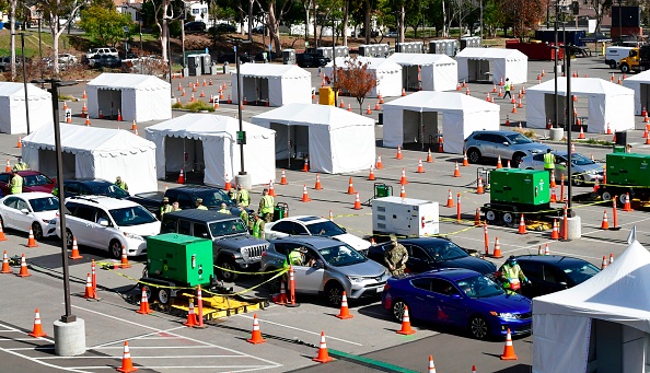 -Les conducteurs de véhicules arrivent à Los Angeles pour que leurs vaccins contre le Covid-19 soient administrés par des membres de la Garde nationale, le 16 février 2021, Californie. Photo par Frederic J. Brown / AFP via Getty Images.