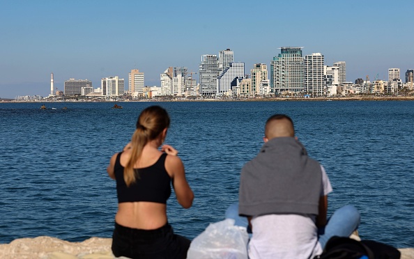 -Un jeune couple partage un pique-nique devant une vue sur les toits de Tel Aviv, dans la ville côtière israélienne, le 15 février 2021. Photo par Emmanuel Dunand / AFP via Getty Images.