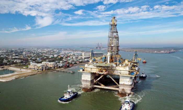 Sur cette image aérienne prise par un drone, des remorqueurs remorquent la plate-forme de forage semi-submersible Noble Danny Adkins à travers le canal de Port Aransas dans le Golfe du Mexique à Port Aransas, Texas, le 12 décembre 2020. (Tom Pennington/Getty Images)