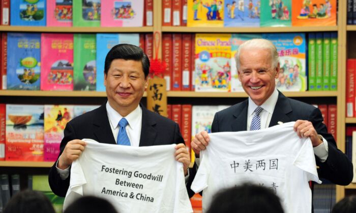 Joe Biden, vice-président américain, et Xi Jinping, son homologue chinois  à l’époque, montrent des T-shirts avec un message encourageant le rapprochement sino-américain qui leur ont été remis par des étudiants de l'International Studies Learning School à Southgate, près de Los Angeles, le 17 février 2012. (FREDERIC J. BROWN/AFP via Getty Images)

