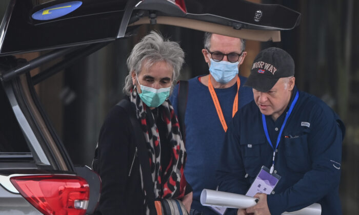 Peter Daszak (à droite) et Marion Koopmans (à gauche), membres de l'équipe de l'OMS, sont accompagnés par Peter Ben Embarek (à droite) alors qu'ils quittent leur hôtel à Wuhan, une ville de la province du Hubei, en Chine centrale, le 10 février 2021. (Hector Retamal/AFP via Getty Images)