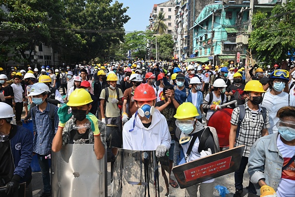 -Des manifestants tiennent des boucliers artisanaux lors d'une manifestation contre le coup d'État militaire à Yangon le 3 mars 2021. Photo de STR / AFP via Getty Images.