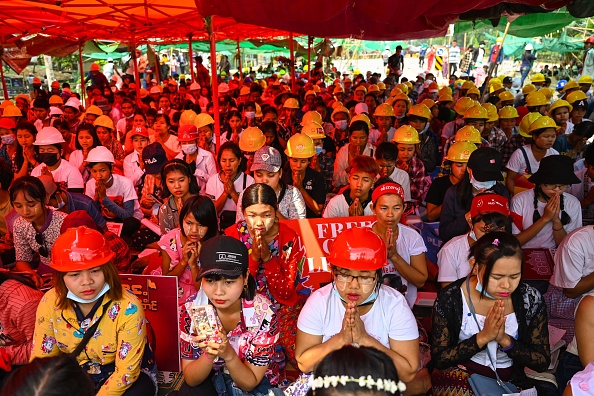 -Des manifestants prient lors d'une manifestation contre le coup d'État militaire à Yangon le 14 mars 2021. Photo de STR / AFP via Getty Images.