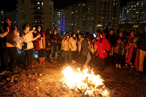 -Des familles iraniennes allument le feu devant leurs maisons à Téhéran le 16 mars 2021 lors de la fête du feu. Photo Atta Kenare / AFP via Getty Images.