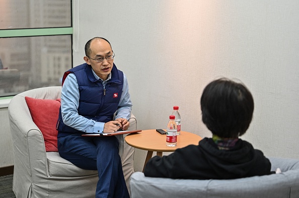 -Le conseiller conjugal Zhu Shenyong conseille un client à Shanghai, le 7 mars 2021. Photo Hector Retamal / AFP via Getty Images.