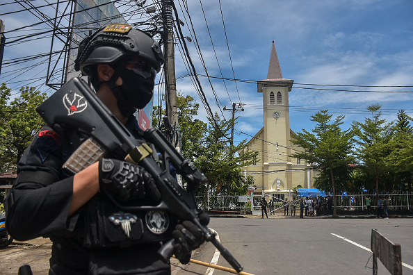 Un policier indonésien monte la garde devant une église après une explosion à Makassar le 28 mars 2021. (Photo : INDRA ABRIYANTO/AFP via Getty Images)