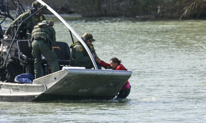 Les agents d'un bateau des douanes et de la protection des frontières américaines sauvent une femme et un enfant qui sont restés coincés en tentant de traverser le Rio Grande pour entrer illégalement aux États-Unis à Eagle Pass, au Texas, le 16 février 2019. (Charlotte Cuthbertson/The Epoch Times)