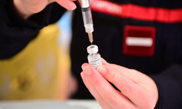 Un pompier prépare une vaccination contre le Covid-19 au centre médical Gymnase Le Moulin à Cergy, en banlieue nord-ouest de Paris, le 13 mars 2021. (Martin Bureau/AFP via Getty Images)