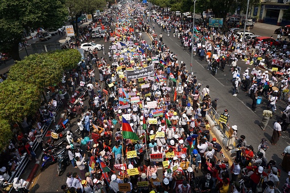 - Des manifestants tiennent des pancartes et des drapeaux ethniques birmans, ils ne vont pas rester les bras croisés. Photo de Sai Aung Main / AFP via Getty Images.