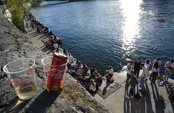 Des personnes se rassemblent sur les berges de la Saône à Lyon, le 31 mars 2021, avant le début du couvre-feu quotidien visant à enrayer la propagation du Covid-19. (PHILIPPE DESMAZES/AFP via Getty Images)