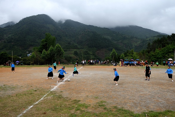 -Des femmes de l’ethnie San Chi vêtues de costumes traditionnels jouent un match de football amical au nord du Vietnam, le 24 avril 2021. Photo de Nhac NGUYEN / AFP via Getty Images.