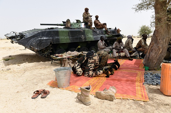 -Des soldats tchadiens prient à côté d'un véhicule blindé le 3 avril 2015, après que la ville du nord-est du Nigéria a été reprise de Boko Haram par les troupes du Tchad et du Niger. Photo Philippe Desmazes / AFP via Getty Images.