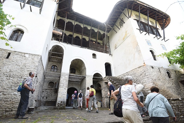 -Des touristes visitent la maison Skenduli dans la ville de Gjirokastra, protégée par l'UNESCO, le 14 juin 2018. Photo par Gent SHKULLAKU / AFP via Getty Images.