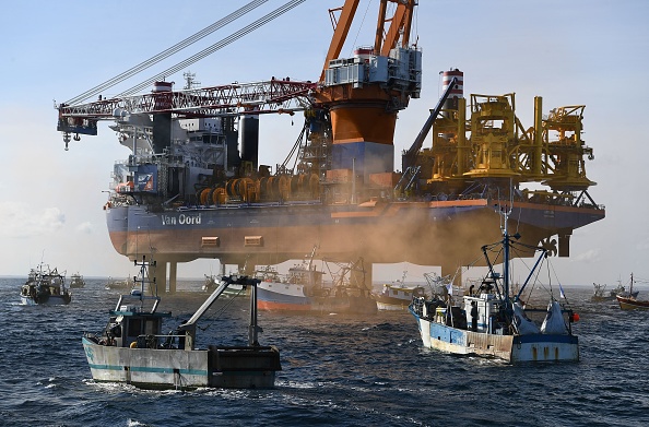 Des bateaux de pêche entourent le navire plate-forme de forage "Aeolus" dans la baie de Saint-Brieuc, pour protester contre le projet de construction de 62 éoliennes en mer. (Photo : FRED TANNEAU/AFP via Getty Images)