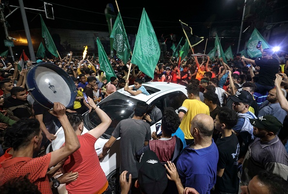 Les gens célèbrent dans les rues le cessez-le-feu négocié par l'Égypte entre Israël et le mouvement islamiste, dans la ville de Gaza le 21 mai 2021. Photo MAHMUD HAMS / AFP via Getty Images.