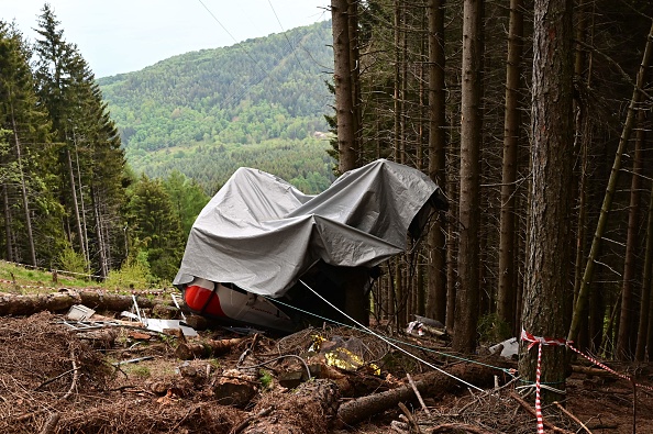 L’épave de la cabine recouverte d'une bâche le 26 mai 2021 sur les pentes du pic Mottarone au-dessus de Stresa. Photo par MIGUEL MEDINA / AFP via Getty Images.