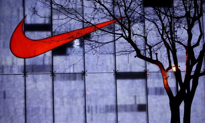 Des habitants de Shanghai passent devant un magasin Nike dans la rue commerçante Nanjing Road, le 17 avril 2010 à Shanghai. Aujourd'hui, 41 % des chaussures Nike sont fabriquées au Viêt Nam, et 32 % en Chine. (Feng Li/Getty Images)