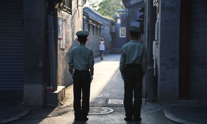 La police paramilitaire chinoise garde une allée dans une rue à côté de la place Tiananmen avant une répétition nocturne d'un défilé militaire pour marquer le 70e anniversaire de la Chine communiste, à Pékin, le 7 septembre 2019. (Greg Baker/AFP via Getty Images)