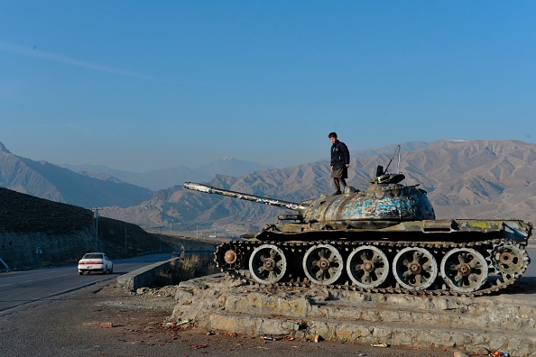 -Un garçon afghan jouant sur l'épave d'un char de l'ère soviétique le long d'une route à la périphérie de Kaboul. Photo par NOORULLAH SHIRZADA/AFP via Getty Images.