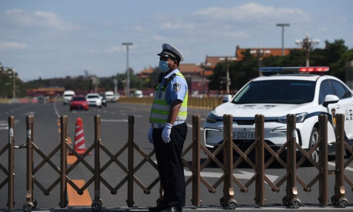 Un officier de police surveille la route qui entoure la place Tiananmen à Pékin, le 4 juin 2021. (Greg Baker/AFP via Getty Images)