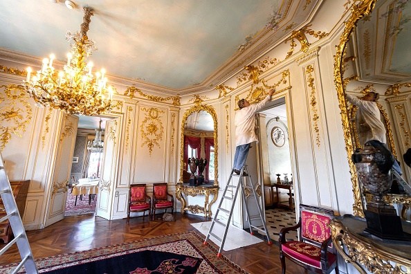 -Un peintre apporte la touche finale à la décoration ornementale à l'intérieur de la "Villa La Grange" où le président américain Joe Biden et le président russe Vladimir Poutine doivent se réunir, à Genève. Photo de Fabrice COFFRINI / AFP via Getty Images.