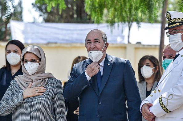 -Le président algérien Abdelmadjid Tebboune arrive avec son épouse dans un bureau de vote à Bouchaoui, le 12 juin 2021.  Photo de RYAD KRAMDI / AFP via Getty Images.