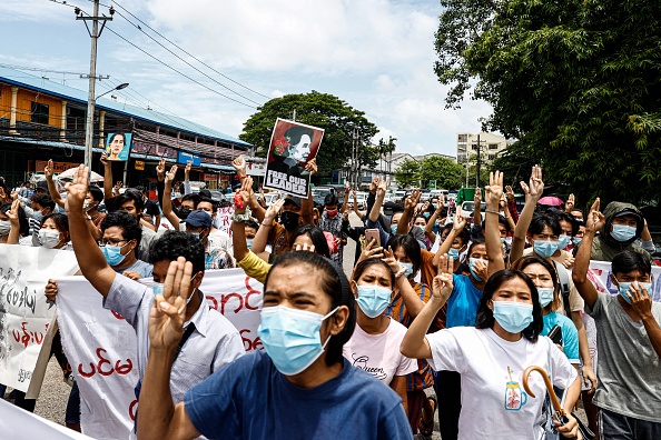 -Les manifestants font le salut à trois doigts et tiennent des affiches de la dirigeante civile birmane détenue Aung San Suu Kyi pour marquer son anniversaire à Yangon le 19 juin 2021. Photo de STR/AFP via Getty Images.