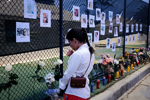 - Des photos de résidents disparus de l'immeuble partiellement effondré dans un mémorial de fortune à Surfside, au nord de Miami Beach, le 25 juin 2021. Photo de Marco BELLO / AFP via Getty Images.