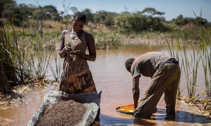 Une femme et un homme séparent le cobalt de la boue et des roches près d'une mine entre Lubumbashi et Kolwezi, en République démocratique du Congo, le 31 mai 2015. (Federico Scoppa/AFP/Getty Images)
