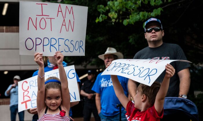 Des membres de la communauté brandissent des pancartes lors d'un rassemblement contre le centre gouvernemental du comté de Loudoun à Leesburg, en Virginie, le 12 juin 2021. (Andrew Caballero-Reynolds/AFP via Getty Images)
