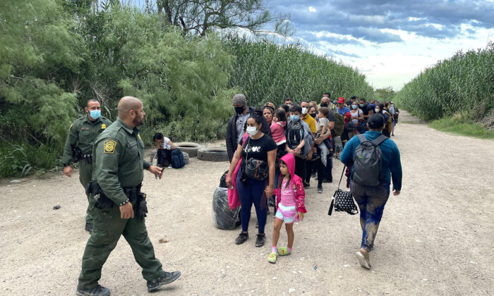 

Un groupe de Vénézuéliens attend d'être pris en charge par la patrouille frontalière après avoir traversé illégalement le Rio Grande du Mexique à Delaware, au Texas, le 3 juin 2021. (Charlotte Cuthbertson/Epoch Times)
