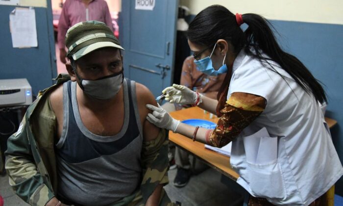 Une travailleuse de la santé inocule un membre de la Force de sécurité frontalière (BSF) avec une dose de vaccin contre le coronavirus Covishield, ChAdOx1 nCoV-19, dans un hôpital civil du village d'Ajnala, à environ 28 km d'Amritsar, le 1er avril 2021, alors que l'Inde étend sa campagne de vaccination contre le coronavirus au groupe d'âge 45-60 ans. (Narinder Nanu/AFP)